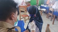 Petugas saat menyuntikkan Vaksin pada salah satu Pelajar