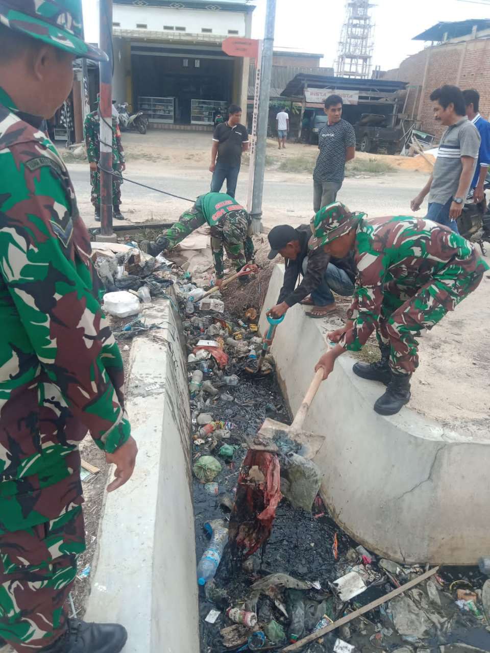 Personel Koramul dan Masyarakat Poleang bahu membahu membersihkan Saluran air.