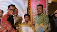 Dr. Mahdar, S.S., M.AP, selaku Direktur Harian Rakyat Sultra, menyerahkan langsung Piagam Penghargaan kepada Kadis Kominfo Kolaka Utara, Batman Batau, S.Pd., M.Pd.