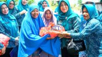 Pj. Ketua TP-PKK Kolut Nina Harini Yuniarti Sukanto saat menyerahkan paket sembako kepada warga