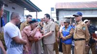 Pj. Bupati Edy Suharmanto saat memberkan bantuan kepada warga korban musibah kebakaran