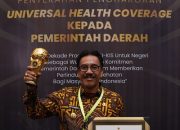 Pj. Bupati Bombana, Edy Suharmanto saat menerima penghargaan Universal Health Coverage (UHC)