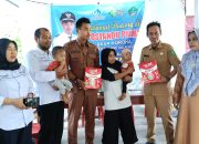 Plt Camat Kodeoha Syahlan Launu, SH saat menyerahkan Susu SGM kepada Anak Penerima
