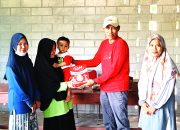 Plt. Camat Kodeoha Syahlan Launu, SH (Berbaju Merah) saat menyerahkan Susu untuk Anak