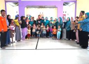Foto bersama dengan orang tua dan balita setelah penerimaan susu gratis.