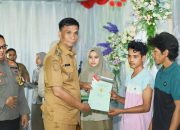 Pj. Bupati Kolaka Utara, Yusmin, S.Pd, MH saat menyerahkan sertifikat secara simbolis