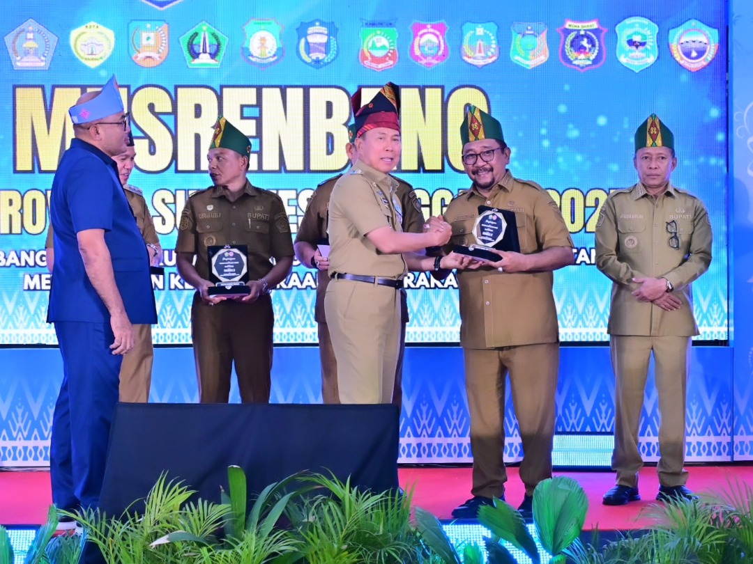 Gubernur Sulawesi Tenggara, Mayjen TNI (Purn) Andi Sumangerukka, S.E., M.M menyerahkan penghargaan kepada Bupati Bombana, Ir. H. Burhanuddin, M.Si